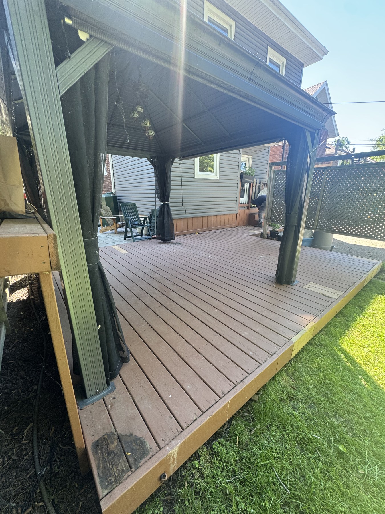 Weathered grey deck under gazebo before staining