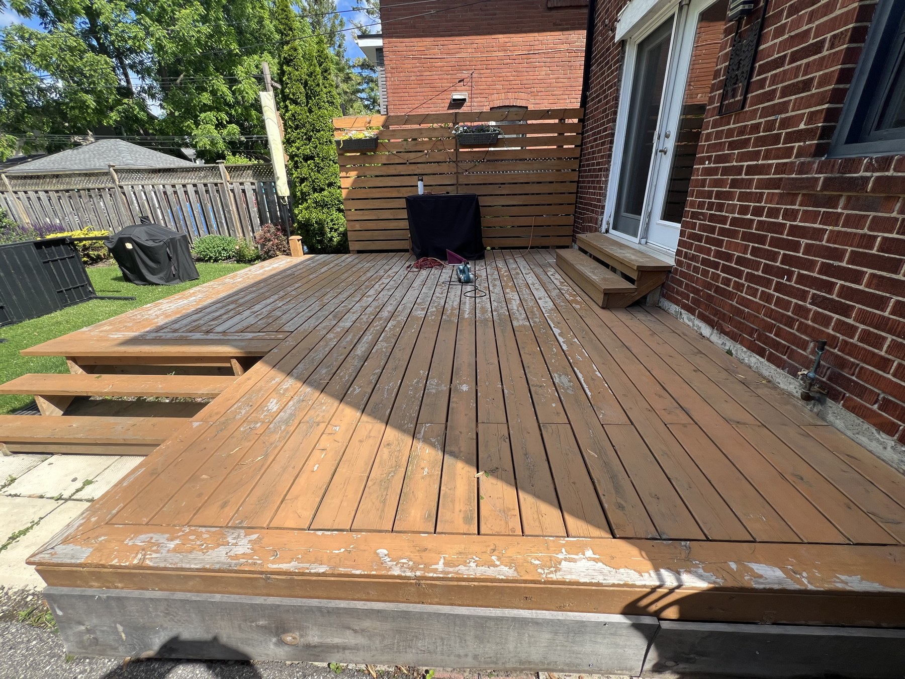 Worn backyard deck with peeling stain before restoration