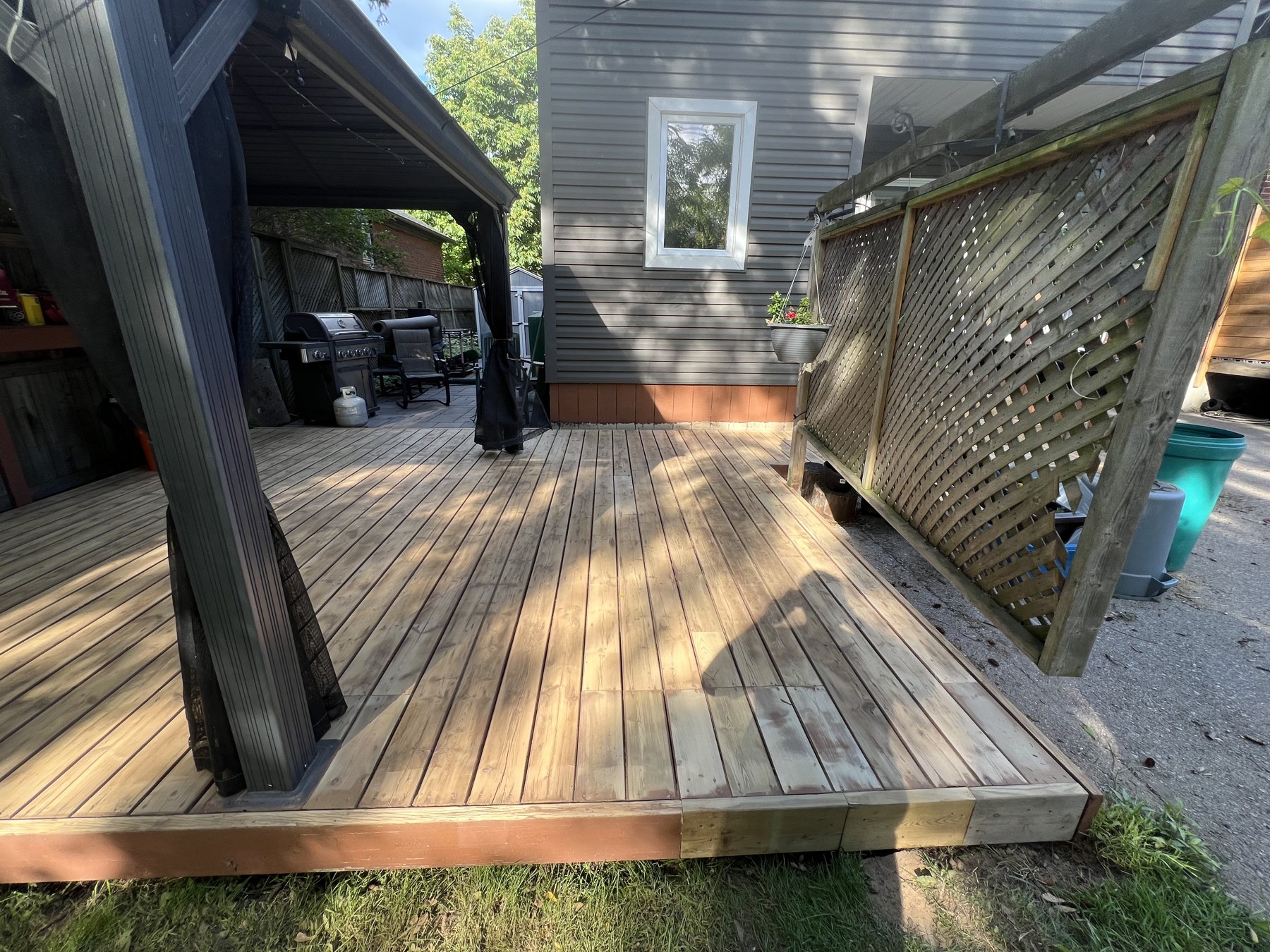 Faded deck by privacy screen before staining